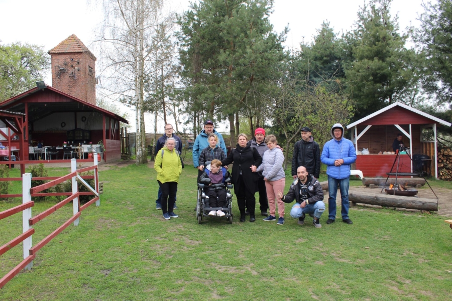 1 – Uczestnicy pozują do zdjęcia grupowego na tle farmy.