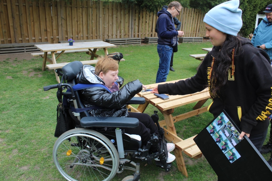 9 -  Pracownik farmy rozdająca Uczestnikom magnesy z wizerunkiem alpak.