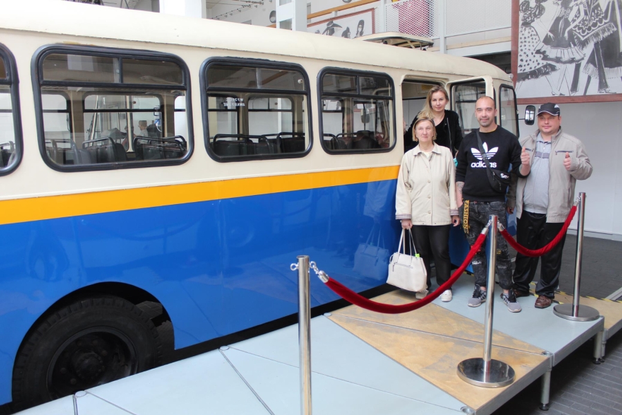 Uczestnicy wraz z terapeutą pozują do zdjęcia na tle autobusu.