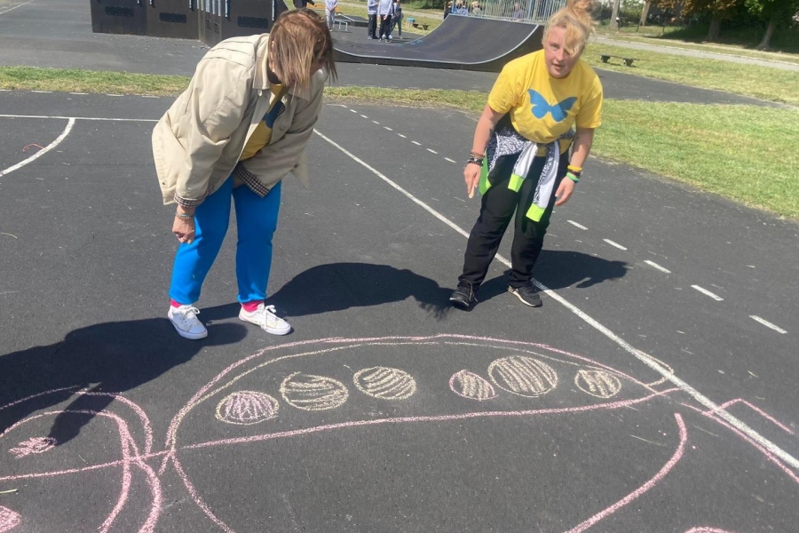 Uczestniczki rysujące biedronkę za pomocą kredy.