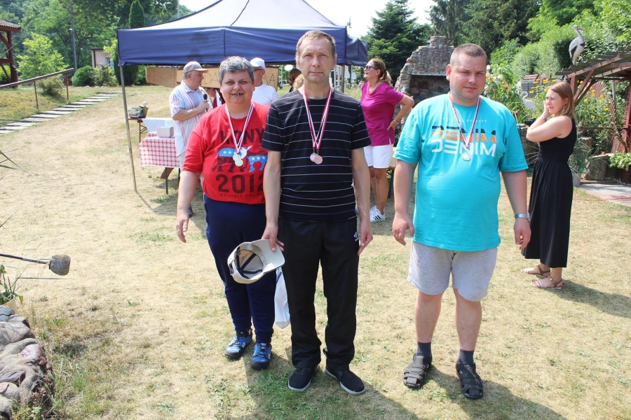 Grupa uczestników pozuje do zdjęcia z medalami. 