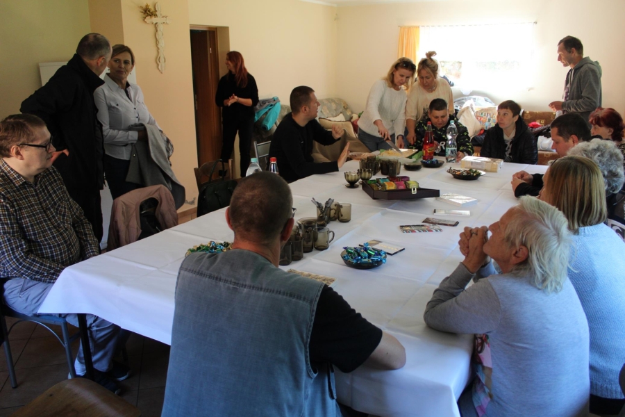 8. Uczestnicy siedzący przy stole podczas poczęstunku.