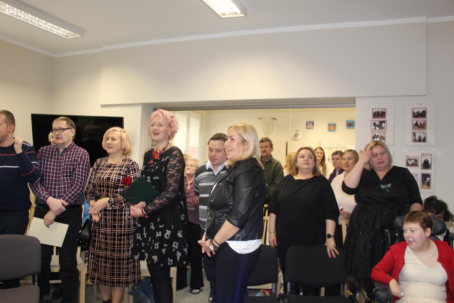 4. Grypa uśmiechniętych, stojących osób śpiewających sto lat