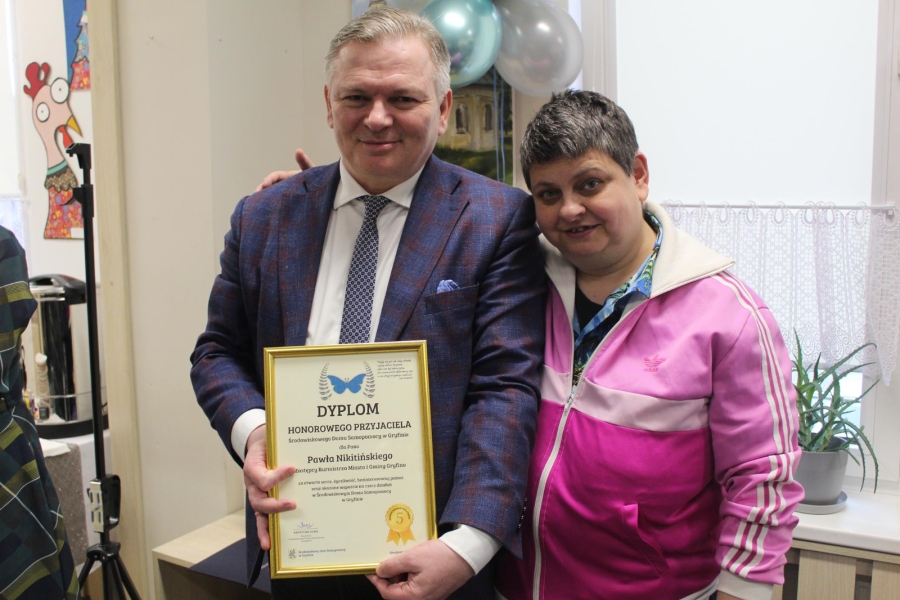 6. Uśmiechająca się uczestniczka wraz Zastępcą Burmistrza Miasta i Gminy Gryfino trzymającym dyplom