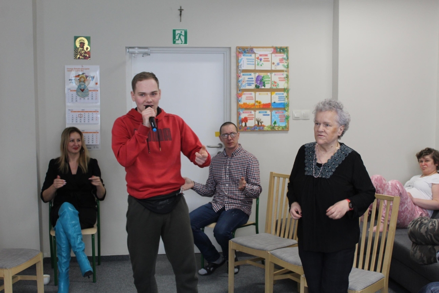 6.Uczestnik śpiewający do mikrofonu na tle grupy