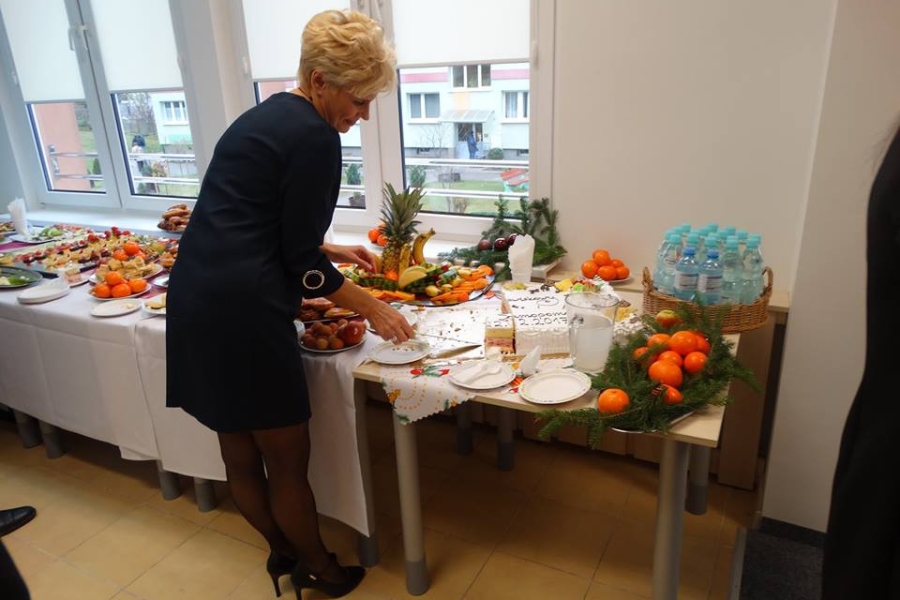 Pani Kierownik podczas krojenia tortu przy stole z poczęstunkiem