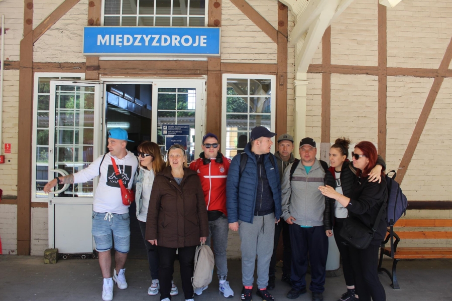 1.Grupa uczestników oraz kadra stojąca przed dworcem PKP w Międzyzdrojach