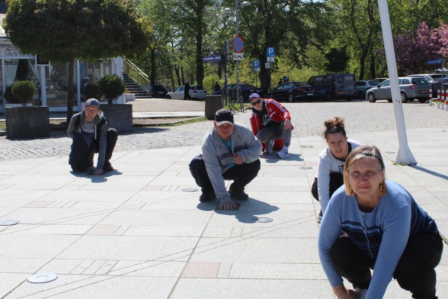 3.Kucający uczestnicy przykładający dłonie do odlewów dłoni przy alei gwiazd