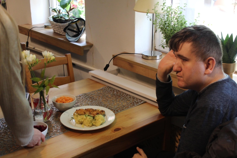 1.Uczestnik opierający się o stół w restauracji