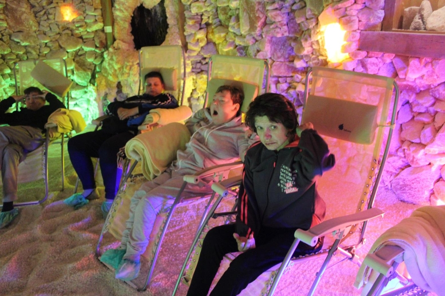 1.Uczestnicy lerzący na leżakach w na tle solnych ścian w komnacie solnej