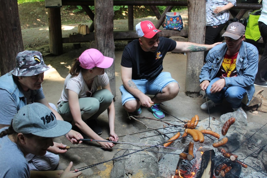 5.Kucający przy ognisku uczestnicy piekący kiełbaski