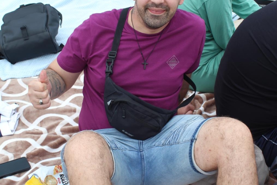 7.Uczestnicy uśmiechają się siedząc na kocu na plaży