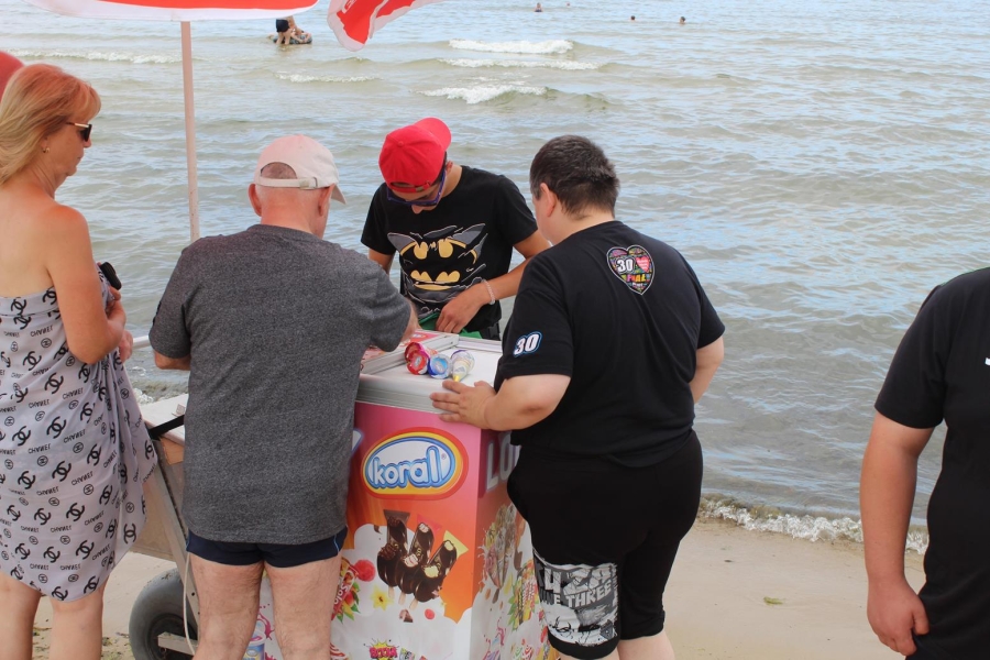 9.Uczestnicy stojący w kolejce po lody na plaży