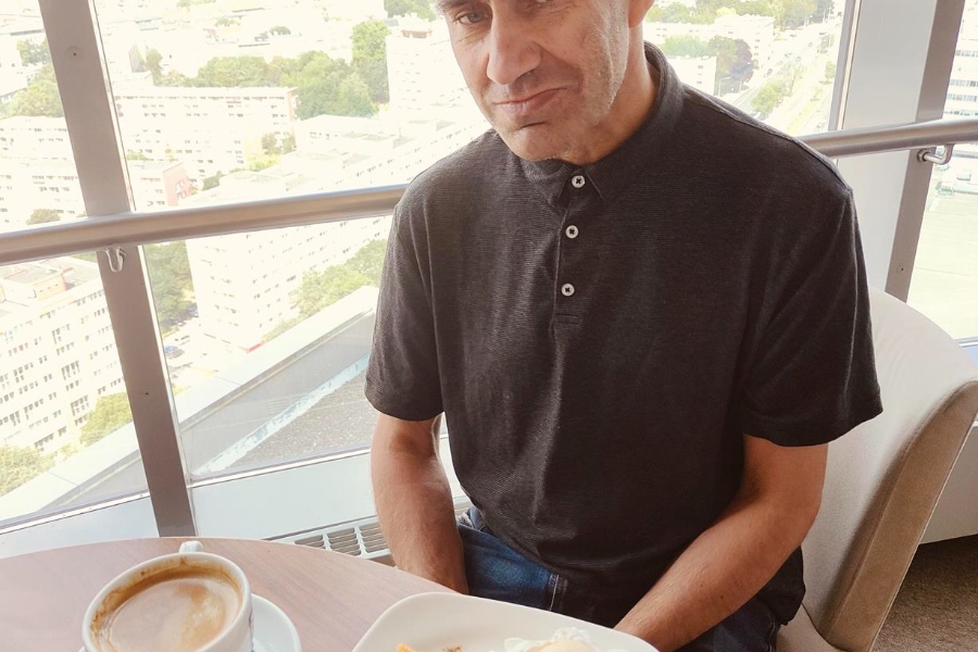 2.Uczestnik przy kawie i szarlotce na tle panoramy szczecina