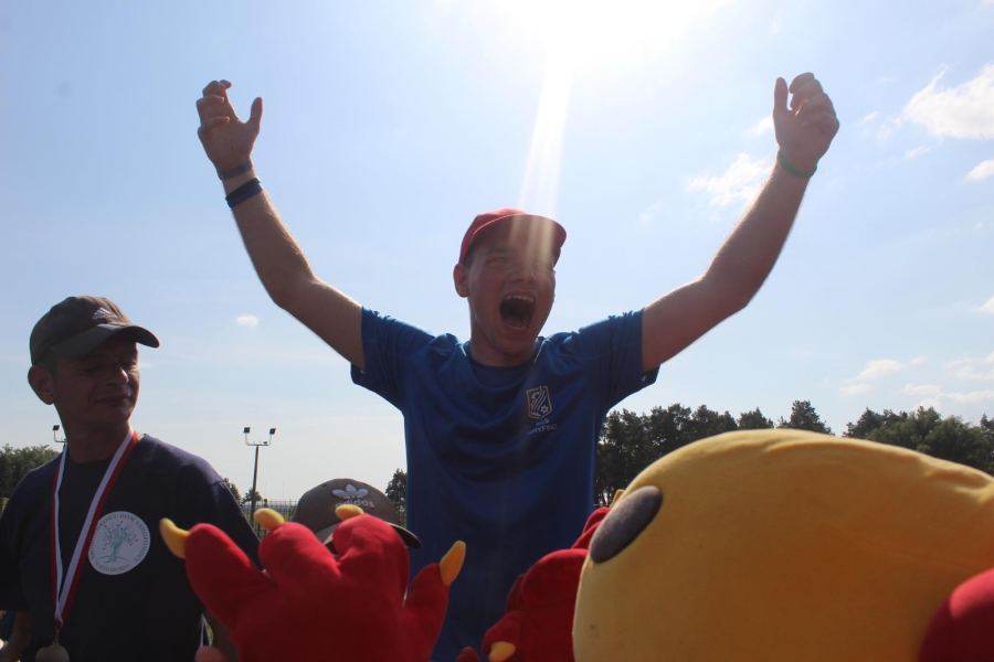 6.Uczestnik na tle nieba krzyczący oraz wznoszący ręce do góry w geście zwycięstwa