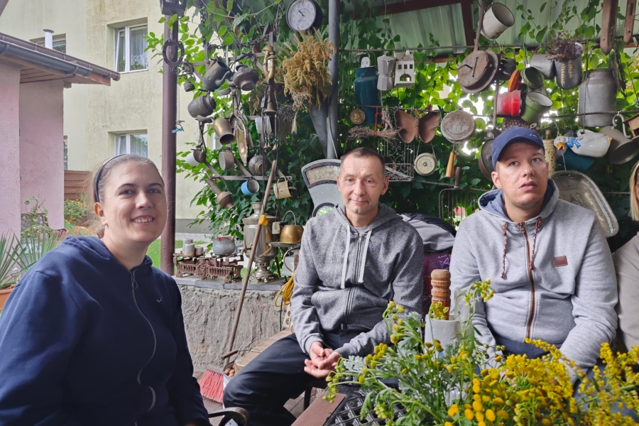 1.Uczestnicy siedzący przy stole na tle ściany z zabytkami