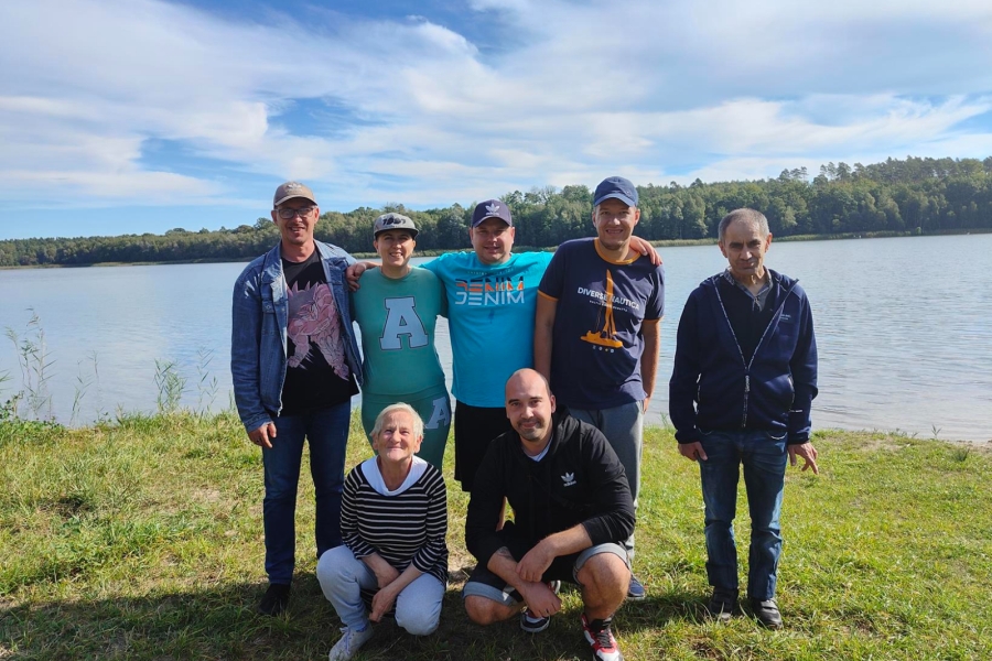 1.Uczestnicy stojący na tle jeziora 