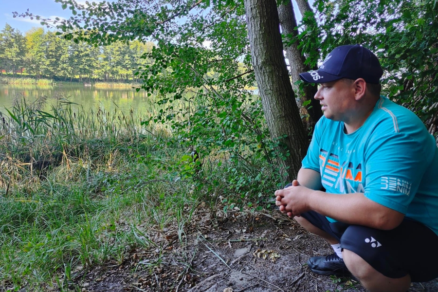 6.Uczestnik kucający patrzący w stronę jeziora