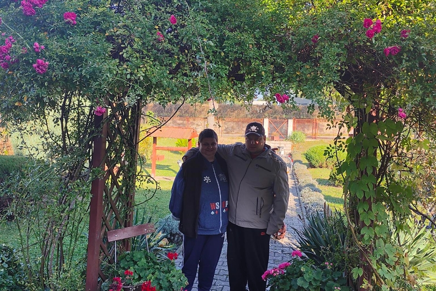 2.Uczestnik obejmujący za ramię uczestniczkę pod kwiecistą bramą