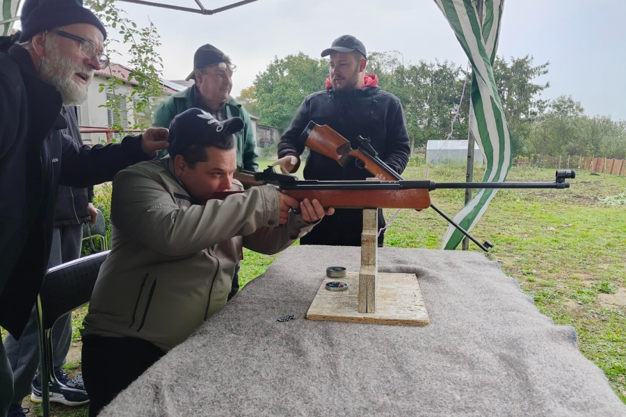 5.Uczestnik na tle instruktorów trzymający strzelający z wiatrówki