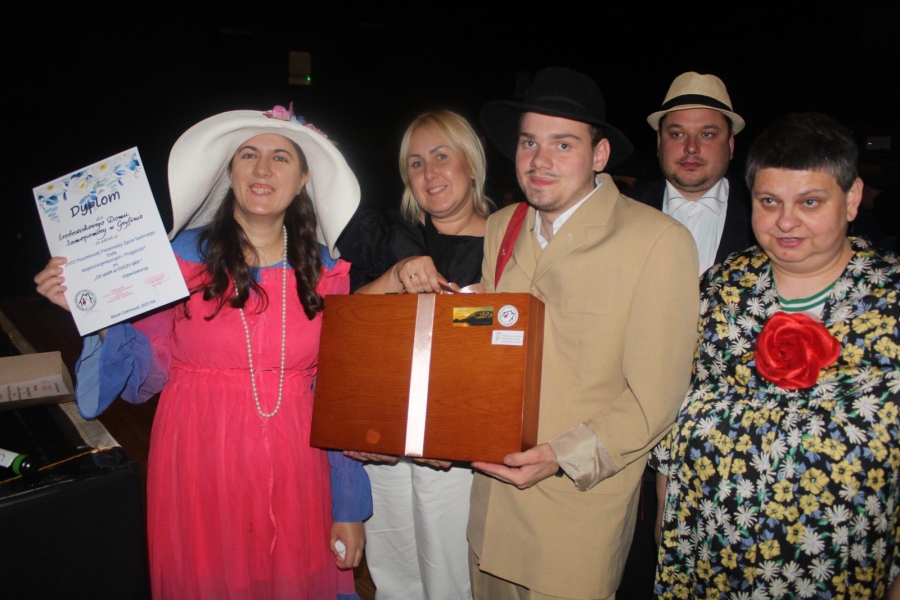 1.Uczestnicy oraz terapeutka w przebraniach trzymający dyplom oraz walizkę