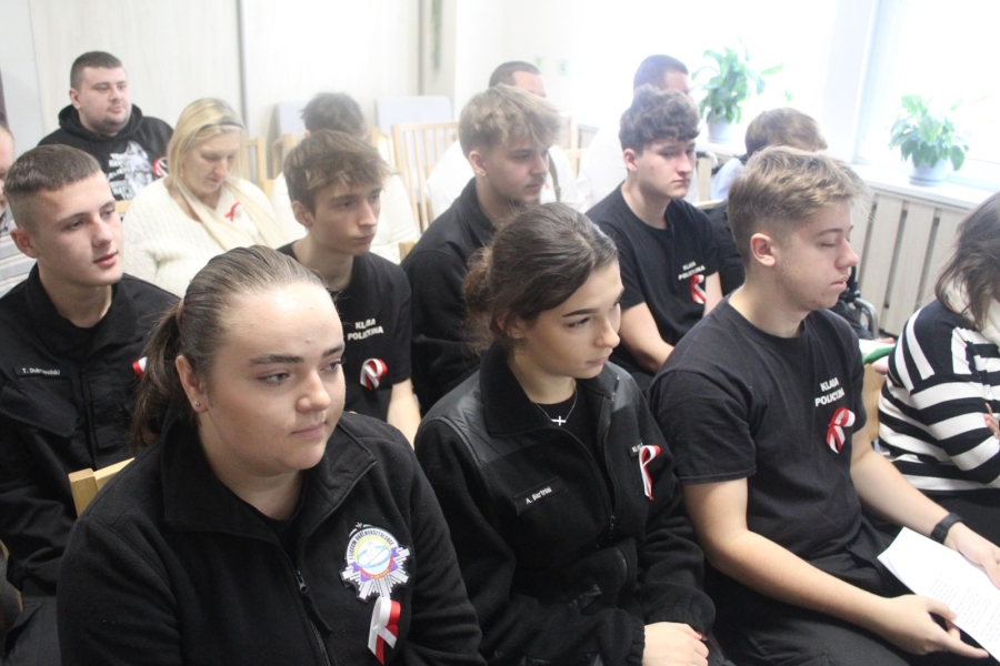 3.Uczniowie klasy policyjnej w czarnych mundurach siedzący na widowni