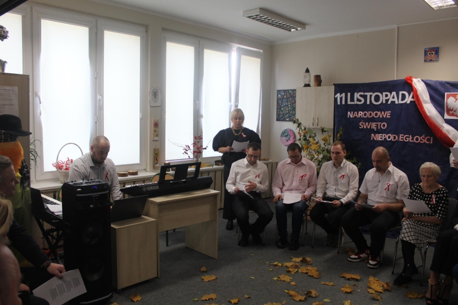 5.Uczestnicy oraz kadra czytający z kartek, na tle rozrzuconych liści oraz napisu 11 listopada