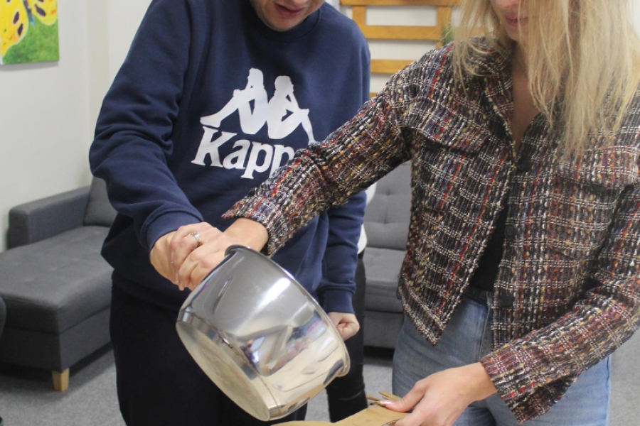 1.Pani Pedagog oraz uczestnik przelewający wosk przez klucz do miski z wodą