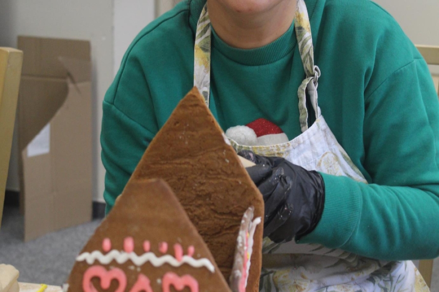 5.Uśmiechająca się Pani Wolontariusz ozdabiająca domek z piernika