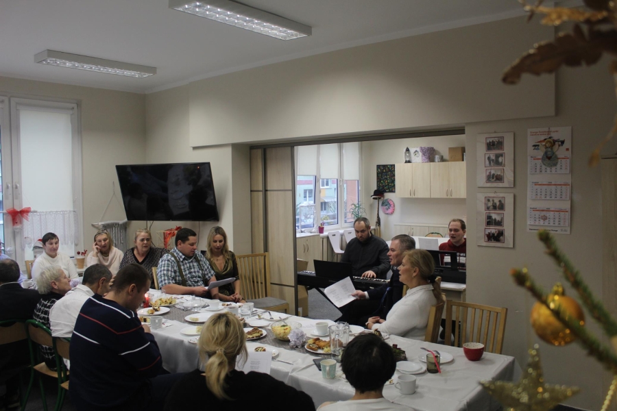 5.Uczestnicy, kadra oraz zaproszeni goście podczas wspólnego kolędowania przy stole wigilijnym