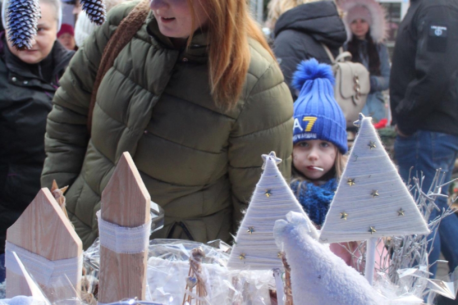 4.Pani przyglądająca się świątecznym pracom na tle namiotów