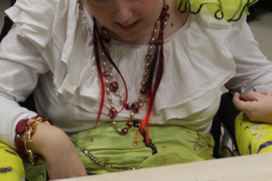 3.Uczestniczka w cygańskim stroju w żółtej chuście na tle palącej się świeczki