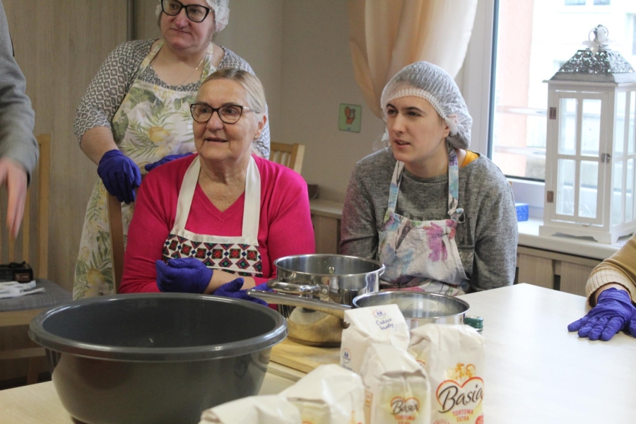 2.Uczestnicy oraz mama uczestnika na tle stołu pełnego produktów spożywczych