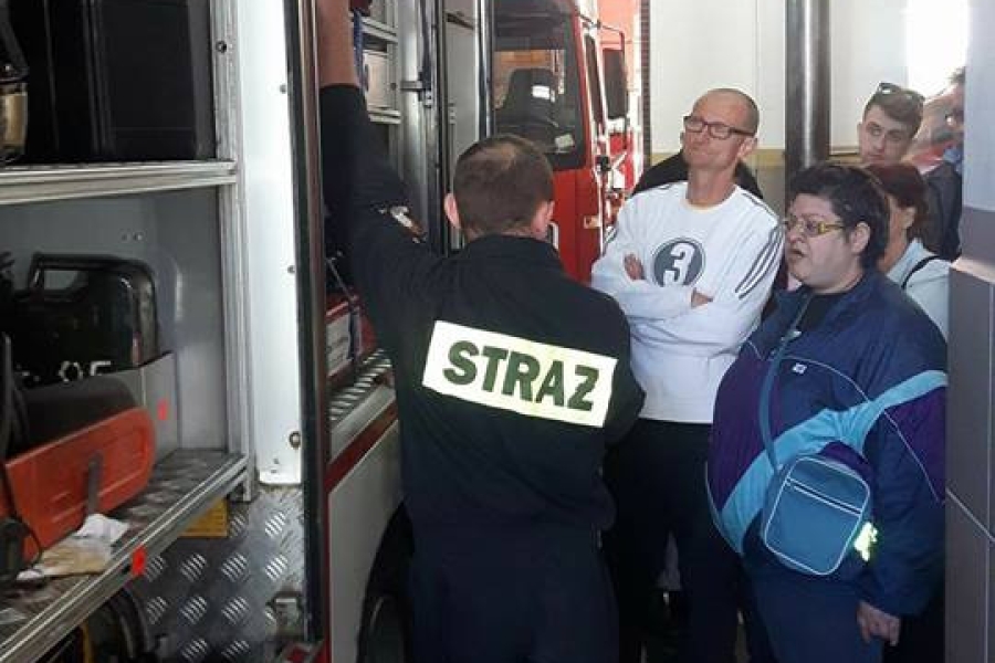 Strażak prezentujący wyposażenie wozu strażackiego