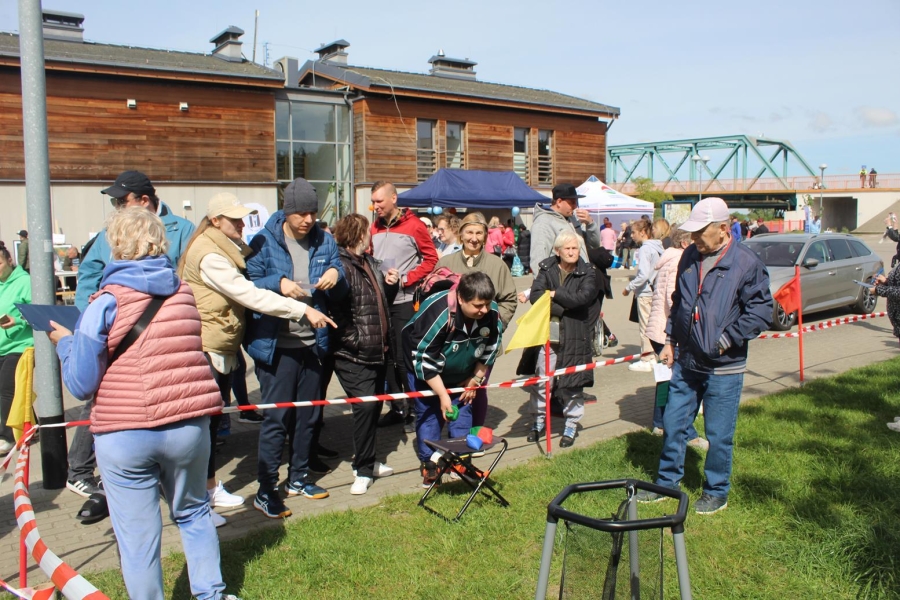 2.Uczestnicy biorący udział w konkurencjach, rzucający woreczkami do celu na tle mostu