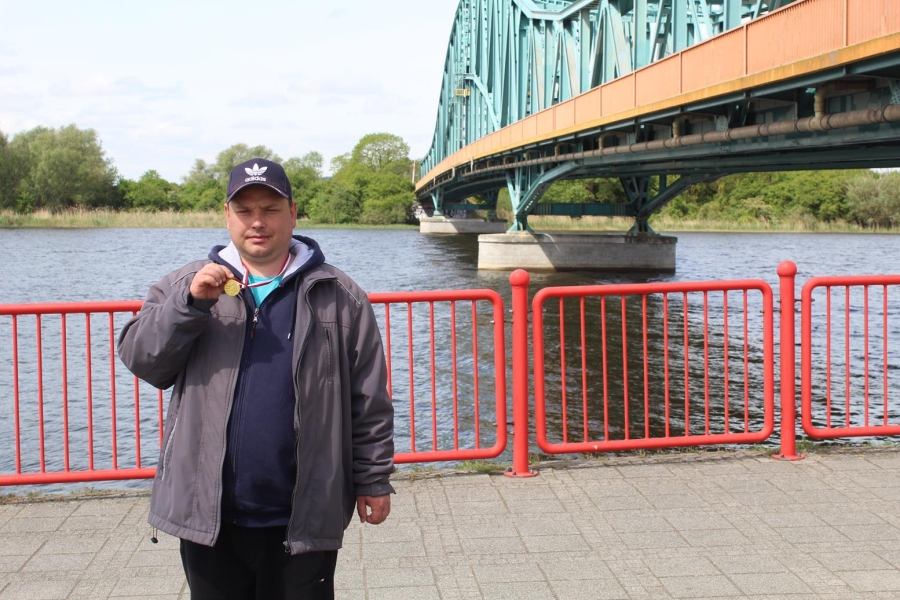 4.Uczestnik prezentujący zdobyty medal na tle mostu gryfińskiego