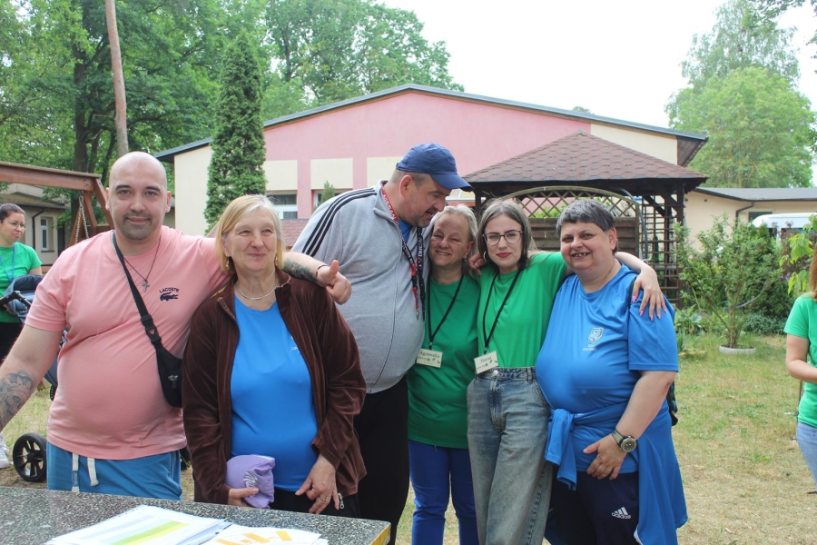 2.Uczestnicy oraz wolontariusze uśmiechający się przy stole ping-pongowym