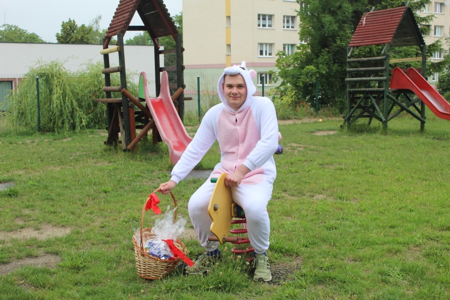6.Uczestnik w przebraniu jednorożca siedzący na drewnianej zabawce na placu zabaw