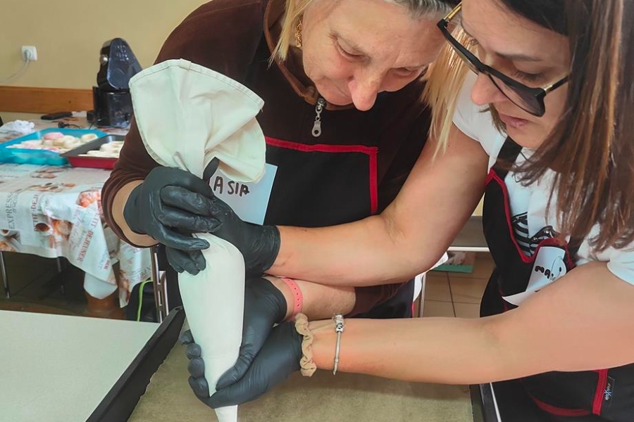 4.Terapeutka WTZ w Goszkowie oraz Uczestniczka ŚDS w Gryfinie nakładające bezę szprycą na blachę.