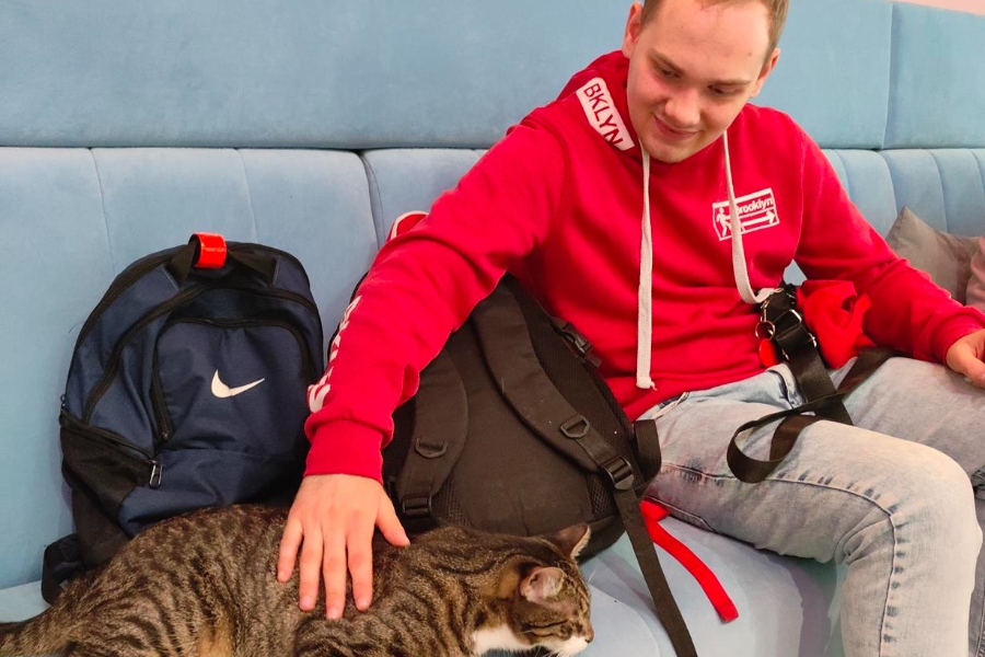 6.Uczestnik na kanapie głaszczący kota