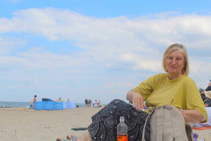 4.Uczestniczka lerząca na kocu na plaży na tle morza