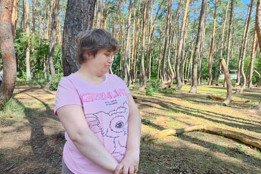 4.Uczestniczka stojąca przy drzewie w krzywym lesie