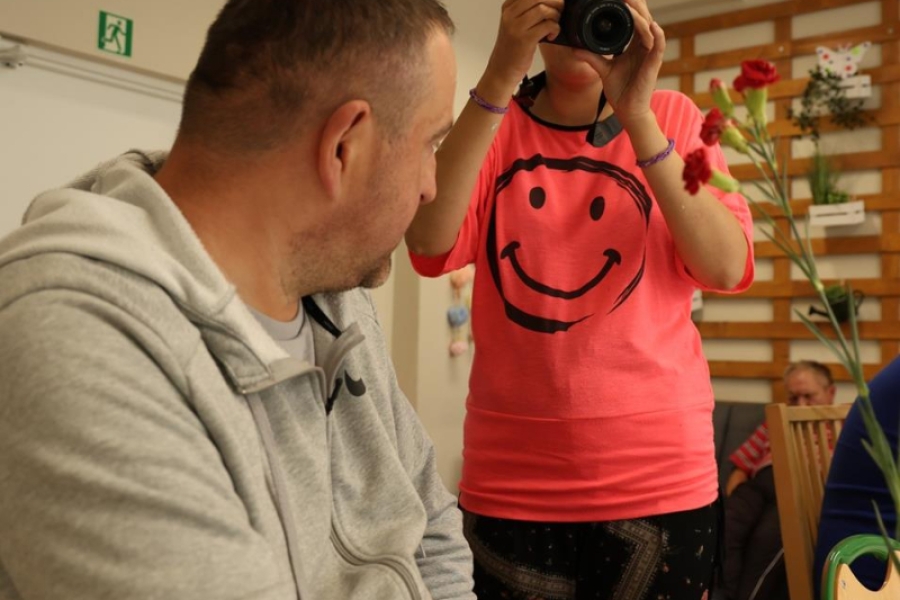 2.Uczestniczka robiąca zdjęcie kwiatów trzymanych przez uczestnika