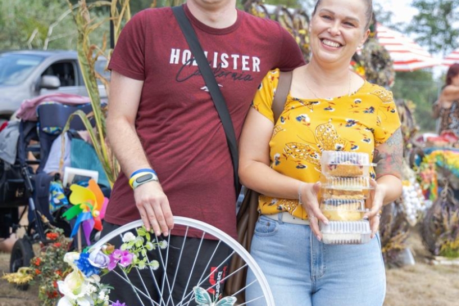 4.Uczestnik oraz jego mama trzymający zdobione kwiatami koło rowerowe