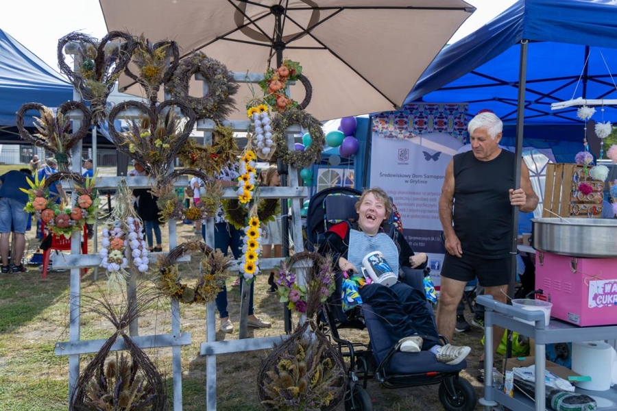 3.Uczestniczka uśmiechająca się na tle wieńców dożynkowych