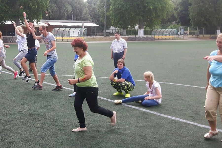 Uczestnicy wykonujący rozgrzewkę na boisku 