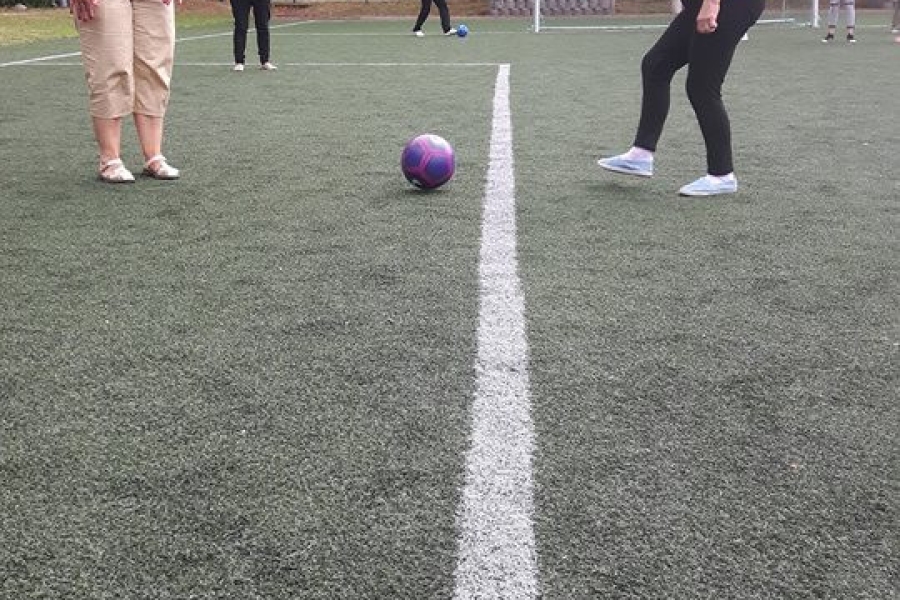 Dwoje uczestników kopiących do siebie piłkę 