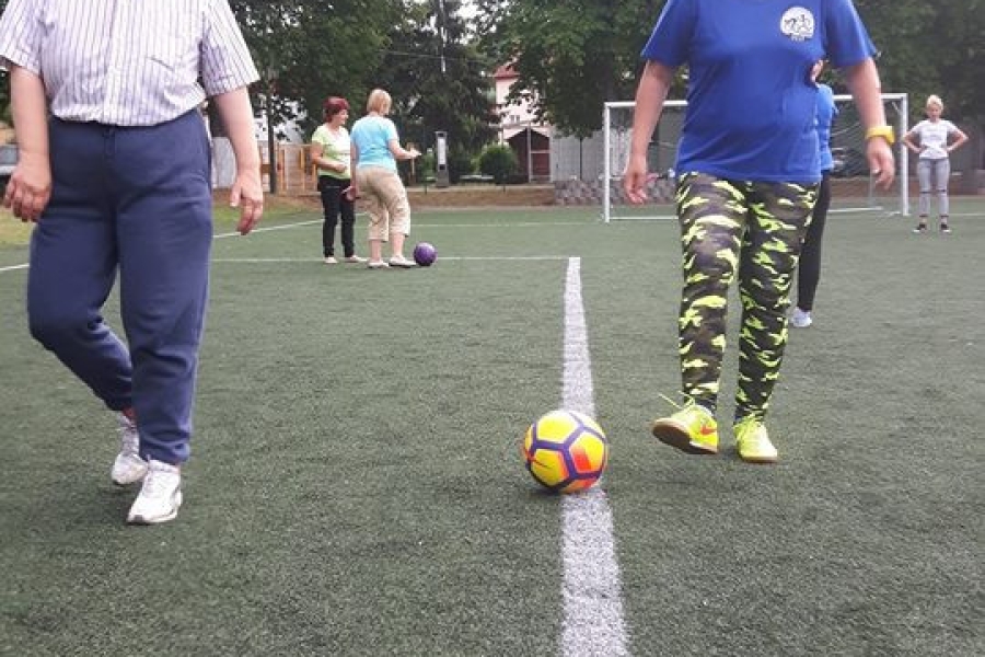 Dwoje uczestników kopiących piłkę wzdłuż linii boiska