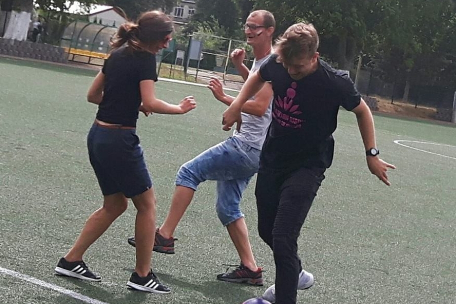 Terapeuta kopiący piłkę na tle innych graczy 