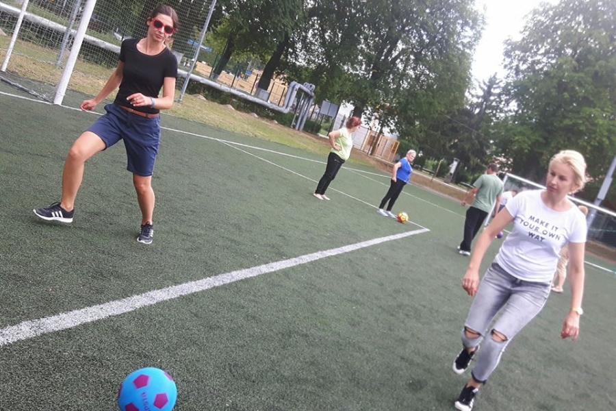 Terapeutki biegnące do piłki na tle pozostałych graczy